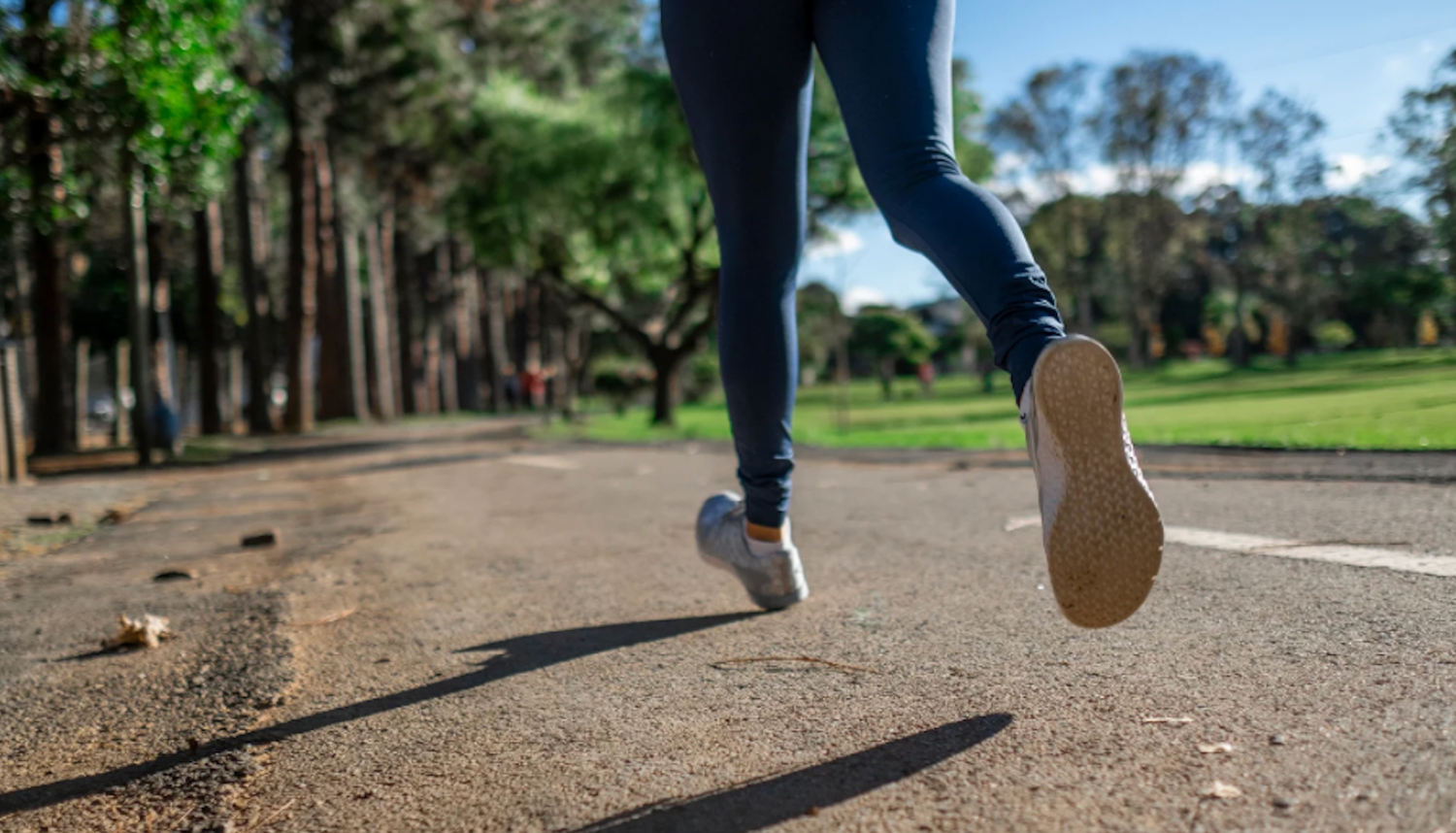 Běžec na lesní cestě zachycen zezadu, zdůrazňující pohyb a zdravý aktivní životní styl.“  Pokud potřebujete další varianty, dejte vědět